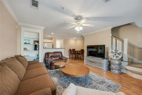 a living room with furniture a flat screen tv and kitchen view