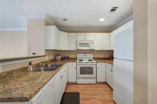 a kitchen with a sink stove top oven and cabinets