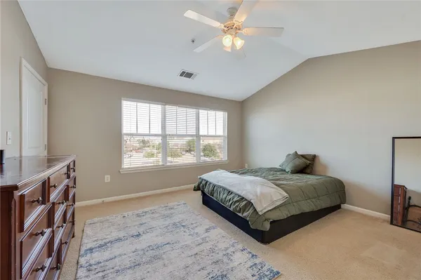 a bedroom with a large bed and a window