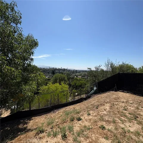 a view of a dry yard with wooden fence