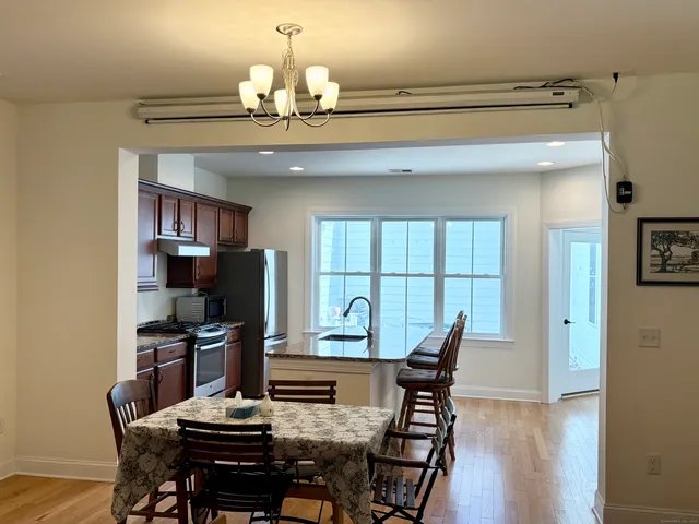 a view of a dining room with furniture a chandelier and wooden floor