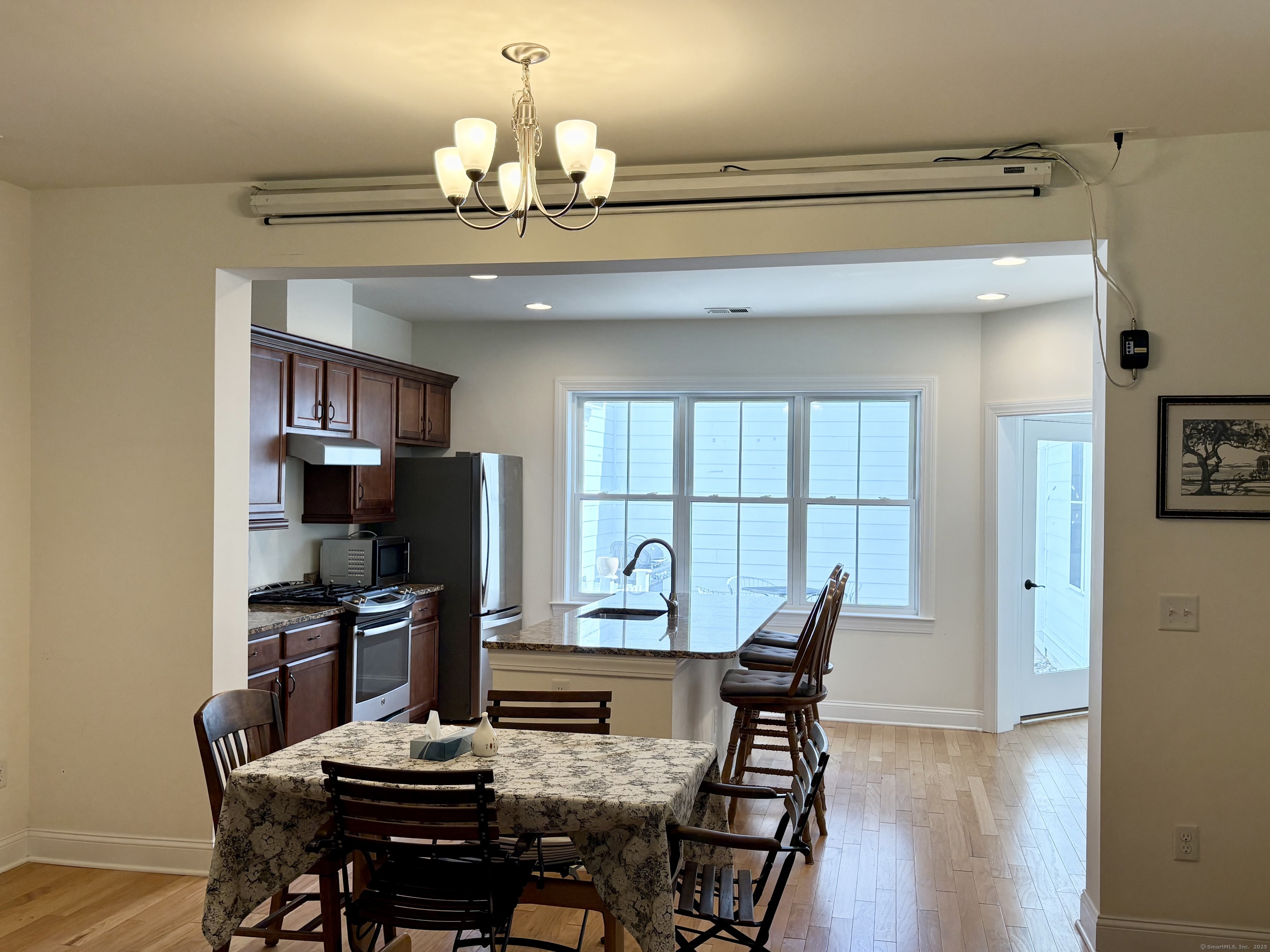 47 Sherwood Street, Unit 47 Mansfield, CT 06268 - Photo 11 of 21 a view of a dining room with furniture a chandelier and wooden floor