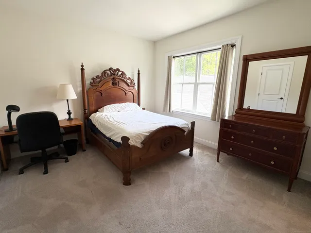 a bedroom with a bed chair and window