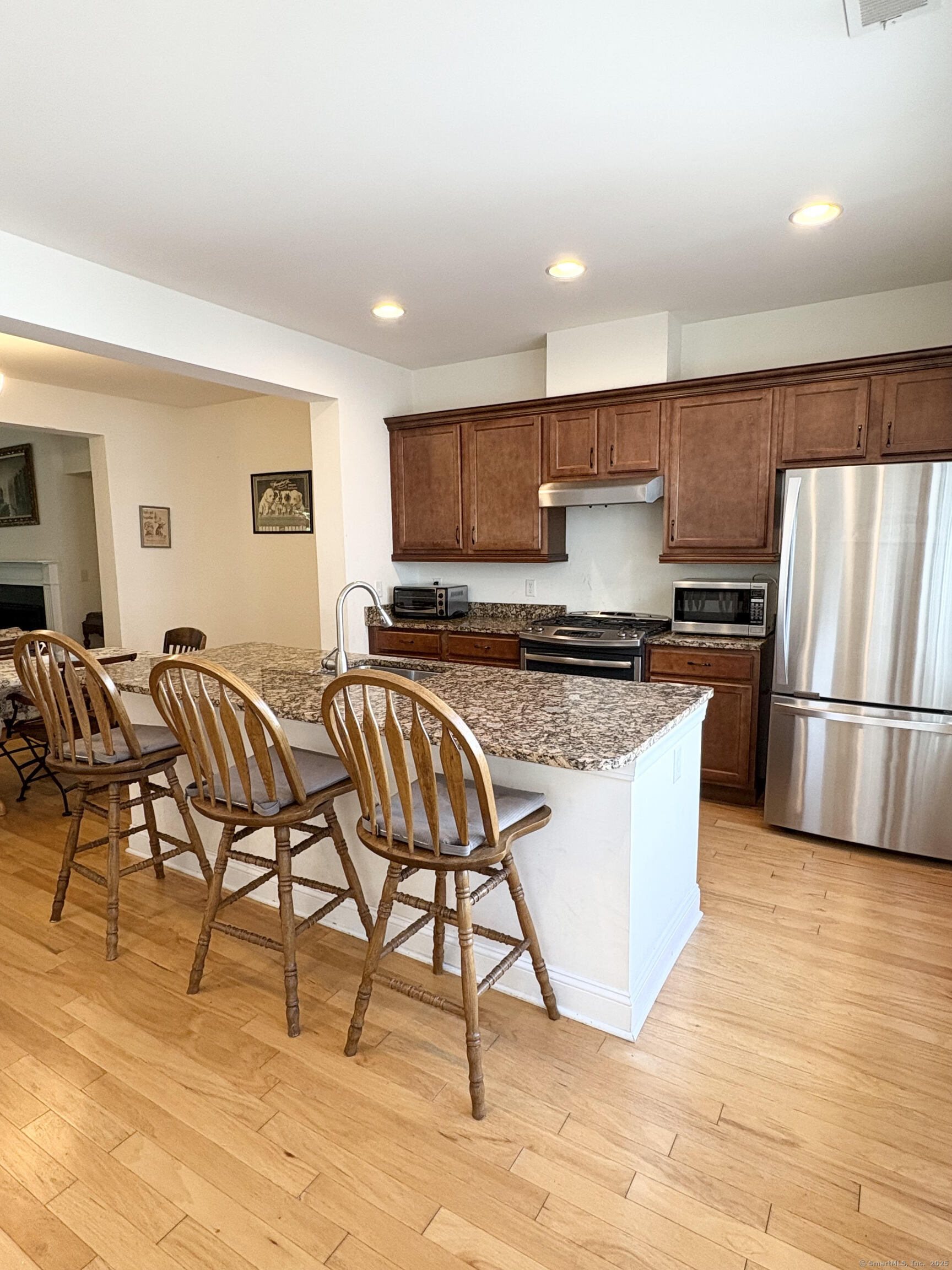 47 Sherwood Street, Unit 47 Mansfield, CT 06268 - Photo 7 of 21 a kitchen with granite countertop a table chairs microwave and cabinets