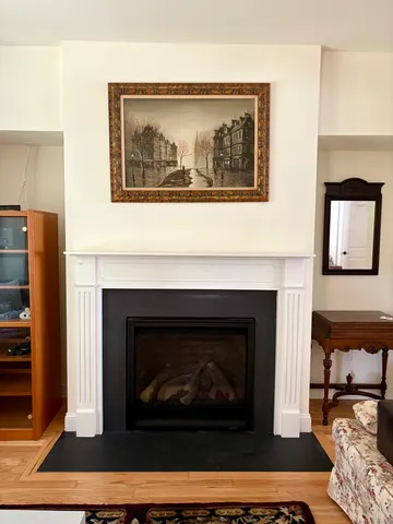 a living room with a fireplace and wooden floor