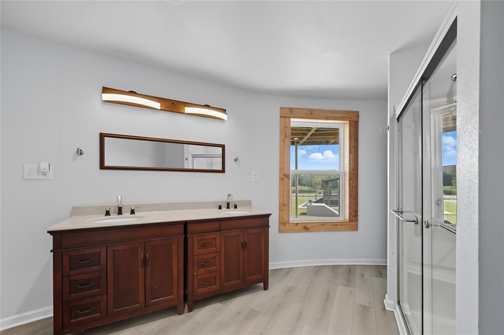 9833 Private Rd. 5377 Nevada, TX 75173 - Photo 13 of 40 a spacious bathroom with a double vanity sink a mirror and a window