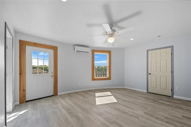an empty room with windows and ceiling fan