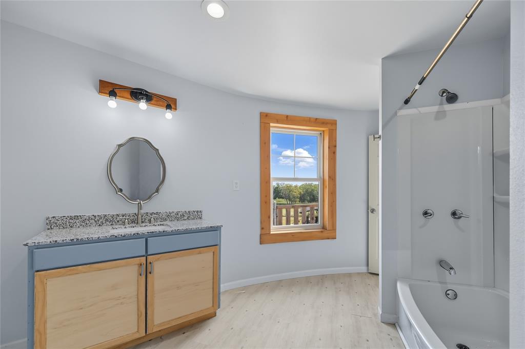 9833 Private Rd. 5377 Nevada, TX 75173 - Photo 19 of 40 a bathroom with a granite countertop sink a mirror and a bathtub