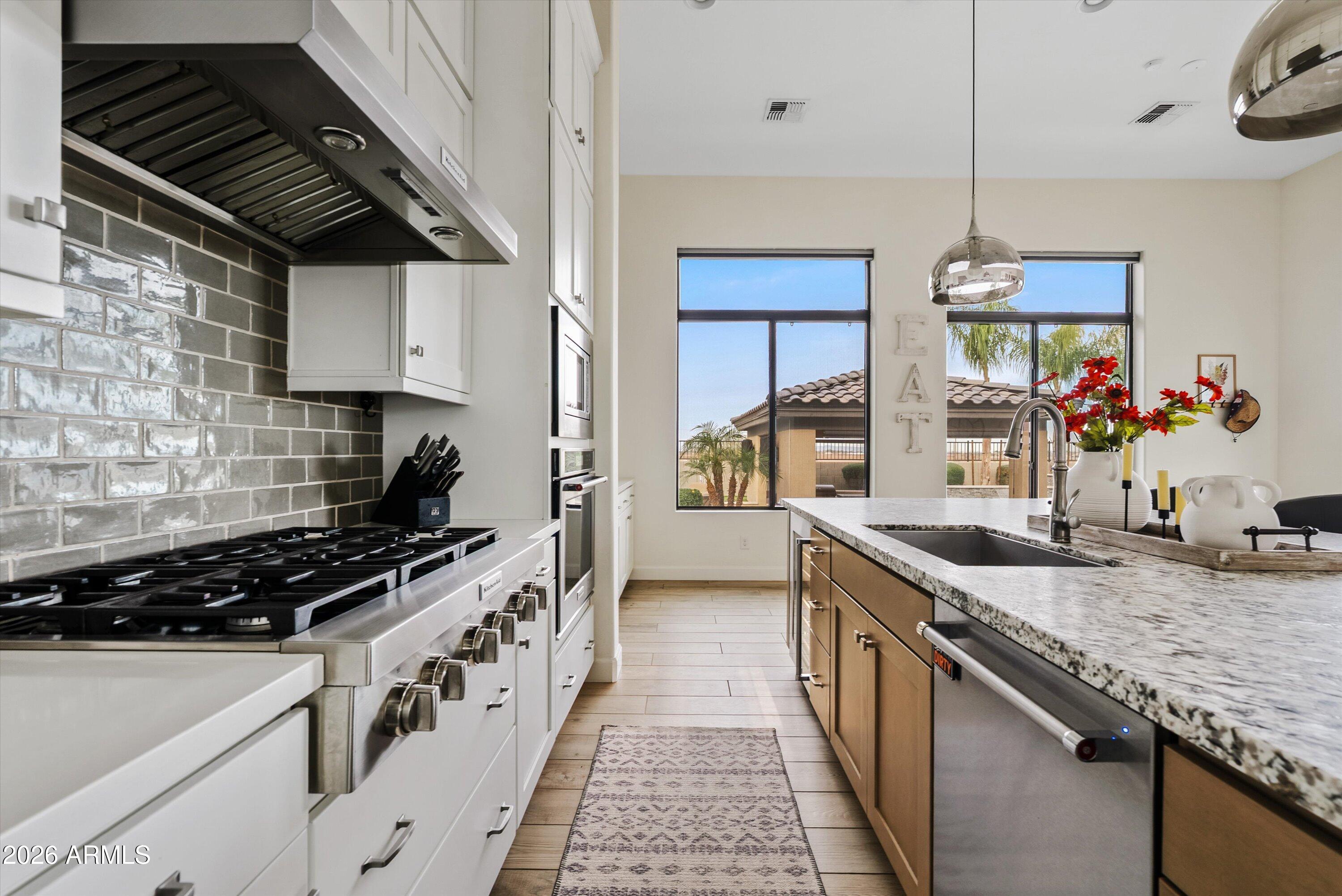7002 South Portland Avenue Gilbert, AZ 85298 - Photo 19 of 40 a kitchen with granite countertop stove a sink dishwasher and a microwave oven