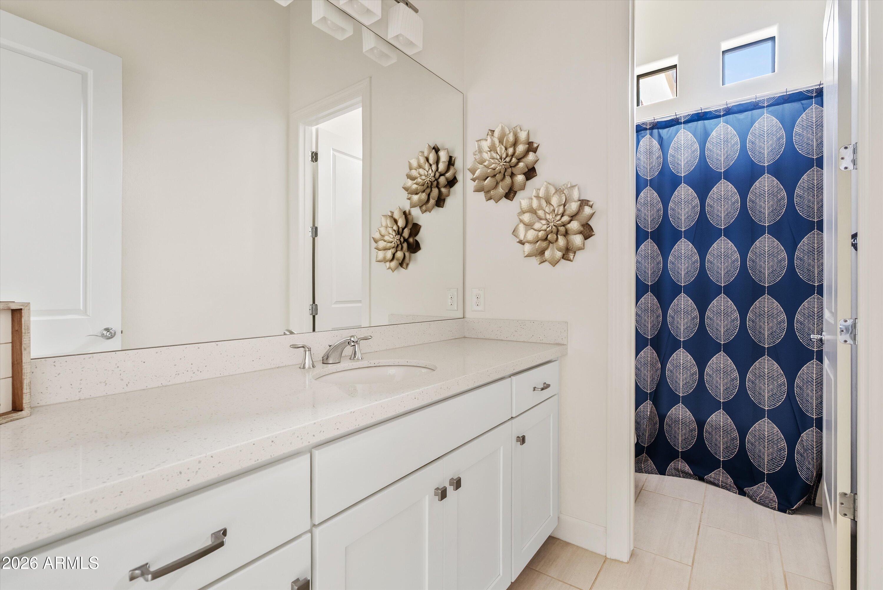7002 South Portland Avenue Gilbert, AZ 85298 - Photo 28 of 40 a bathroom with a granite countertop sink and a mirror