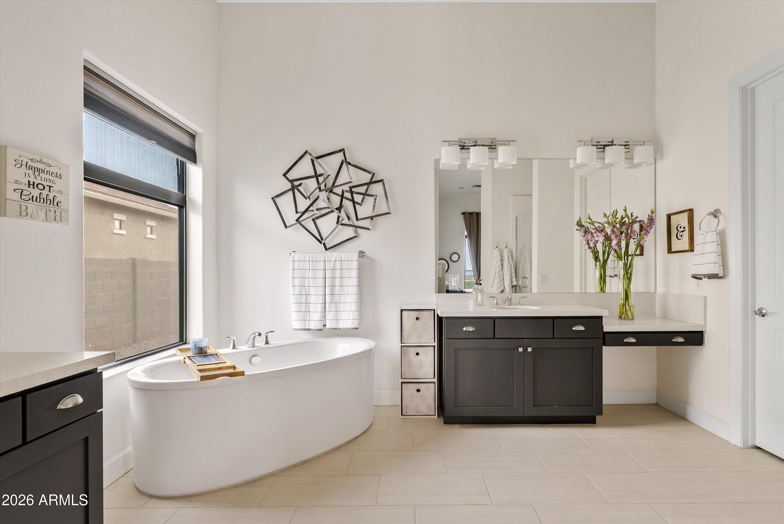 7002 South Portland Avenue Gilbert, AZ 85298 - Photo 30 of 40 a spacious bathroom with a bathtub a sink and a large mirror