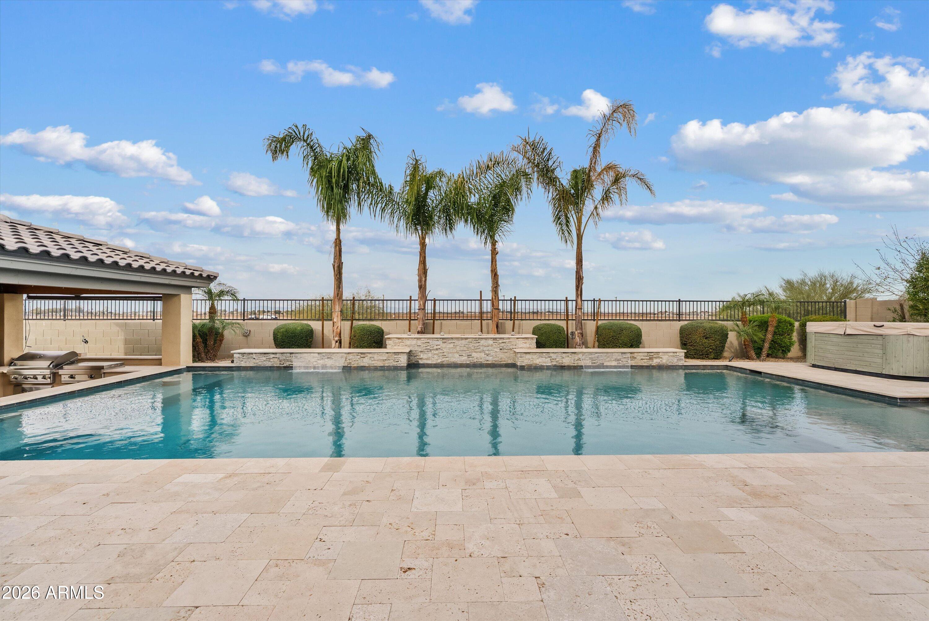 7002 South Portland Avenue Gilbert, AZ 85298 - Photo 35 of 40 a view of a swimming pool with a table and chairs