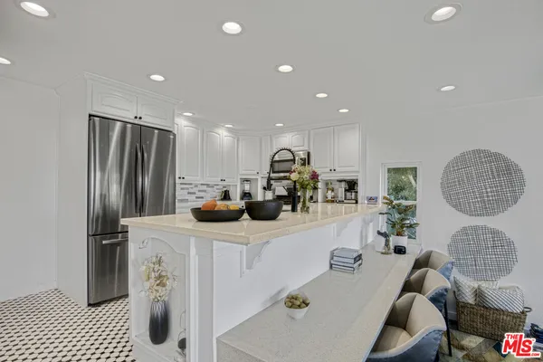 a kitchen with stainless steel appliances granite countertop a sink refrigerator and cabinets