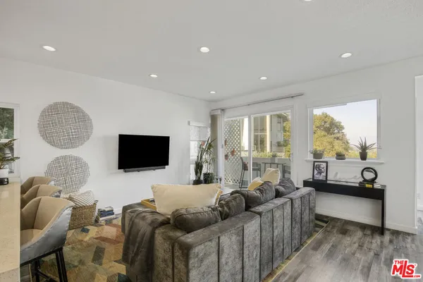 a living room with furniture window and a flat screen tv