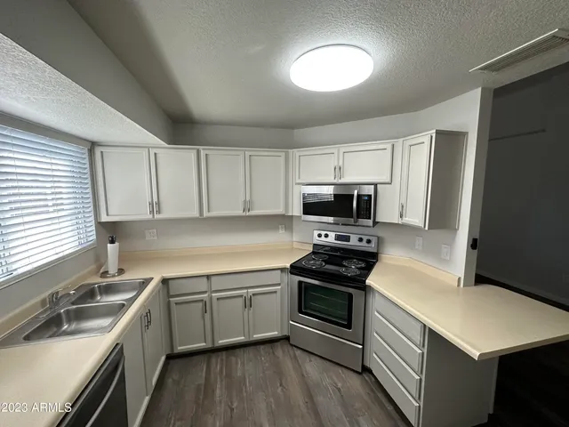 a kitchen with a sink stove top oven and refrigerator