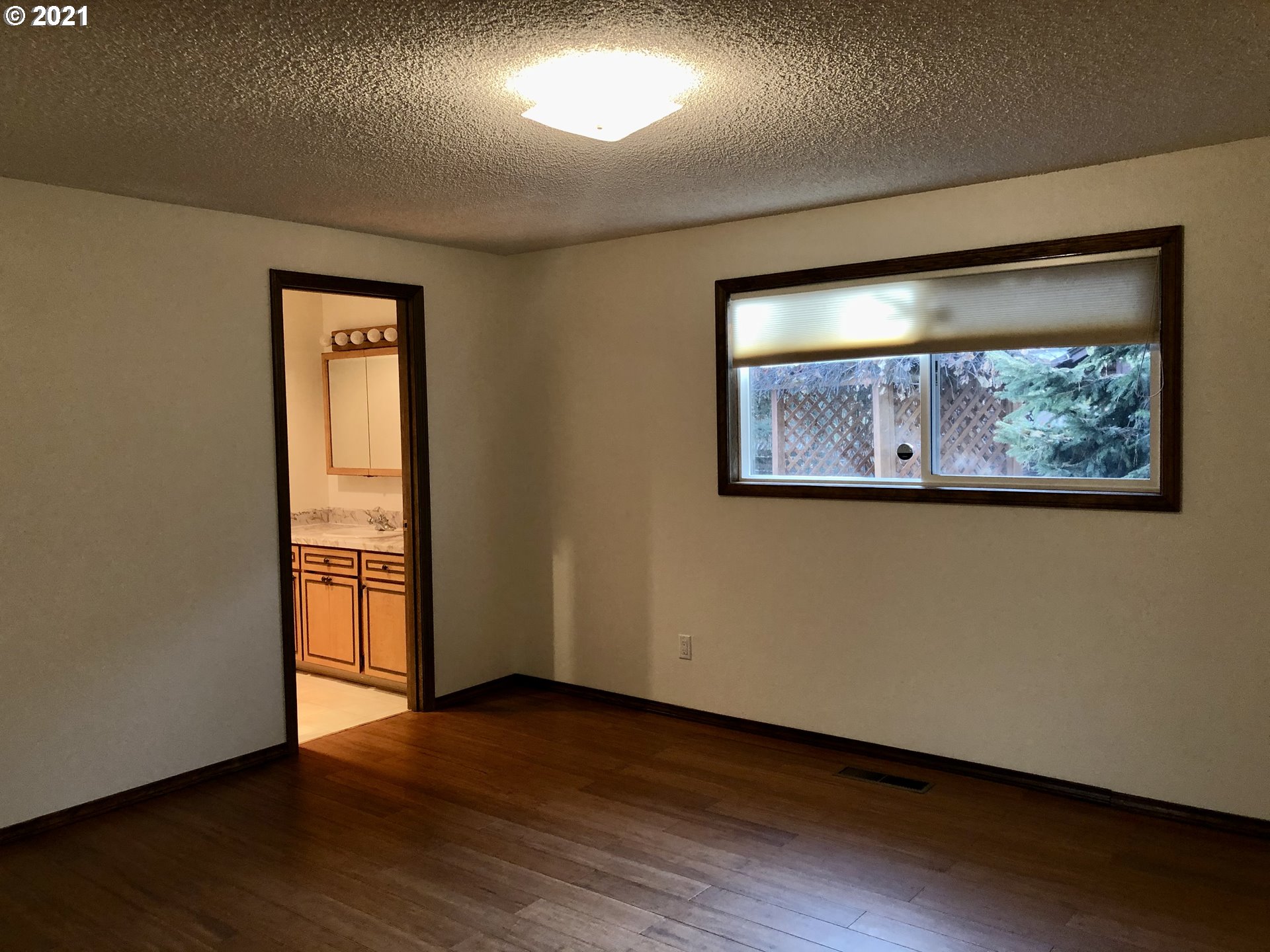 4520 Southwest Olson Avenue Pendleton, OR 97801 - Photo 13 of 22 an empty room with wooden floor and painting on the wall