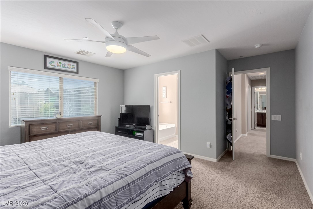 113 Lovage Street Henderson, NV 89002 - Photo 16 of 27 Bedroom featuring light carpet, ceiling fan, and ensuite bathroom