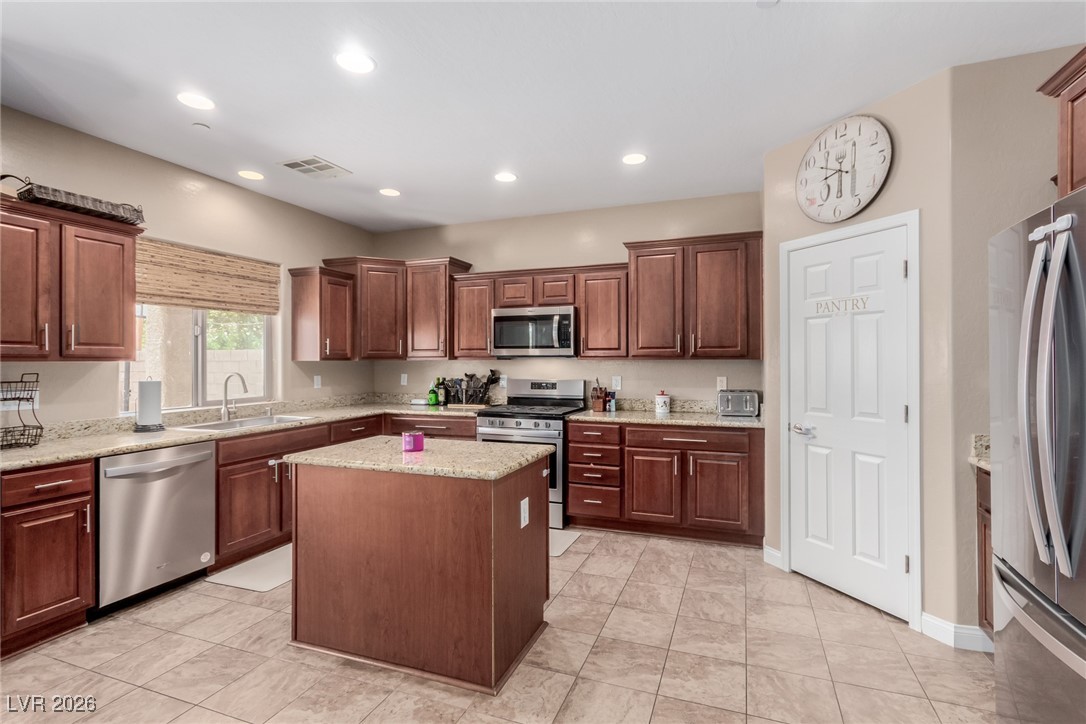 113 Lovage Street Henderson, NV 89002 - Photo 2 of 27 Kitchen featuring stainless steel appliances, light stone counters, recessed lighting, a center island, and light tile patterned floors