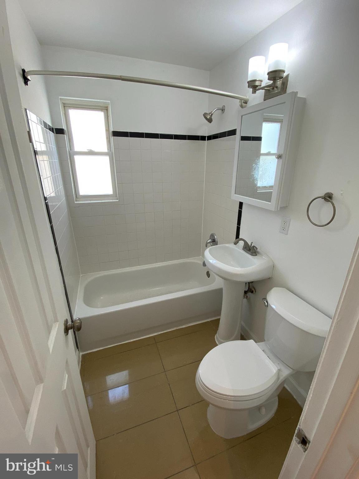 701 Brandywine Street Southeast, Unit 201 Washington, DC 20032 - Photo 11 of 18 a bathroom with a toilet a sink and a shower