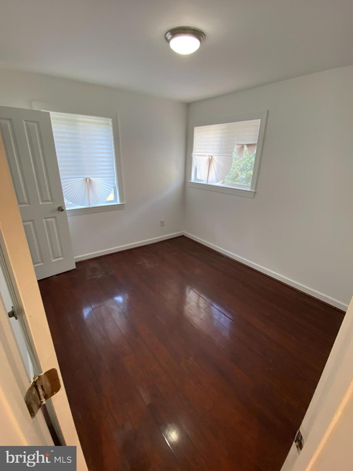 701 Brandywine Street Southeast, Unit 201 Washington, DC 20032 - Photo 16 of 18 a view of an empty room with wooden floor and a window