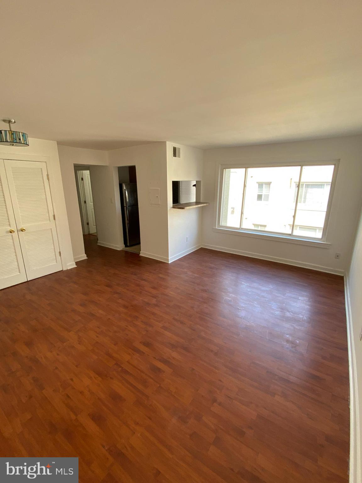 701 Brandywine Street Southeast, Unit 201 Washington, DC 20032 - Photo 4 of 18 an empty room with wooden floor and windows