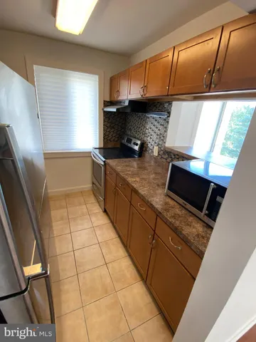 a kitchen with stainless steel appliances kitchen island granite countertop a sink stove and cabinets