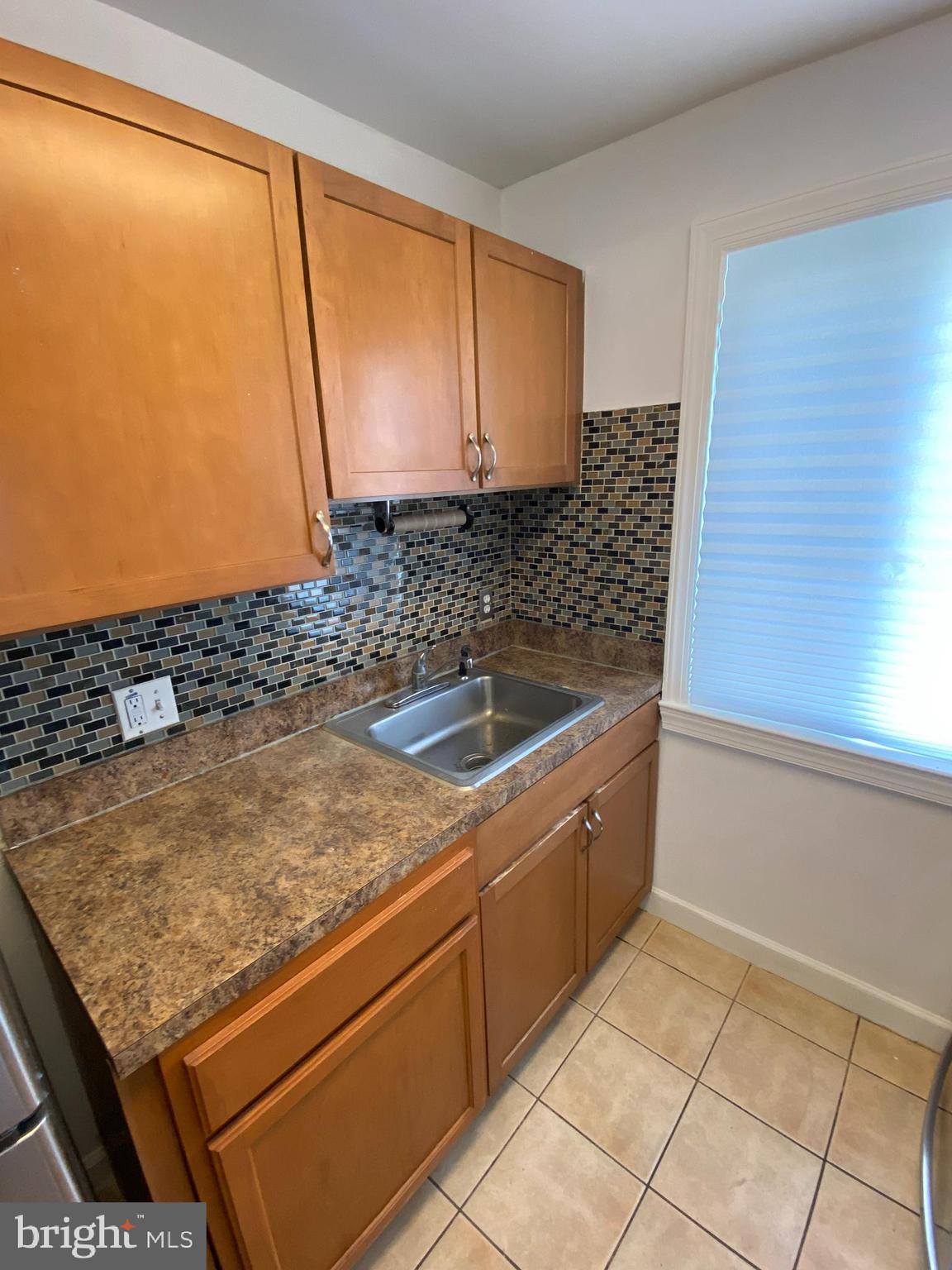701 Brandywine Street Southeast, Unit 201 Washington, DC 20032 - Photo 9 of 18 a bathroom with a granite countertop sink and a mirror
