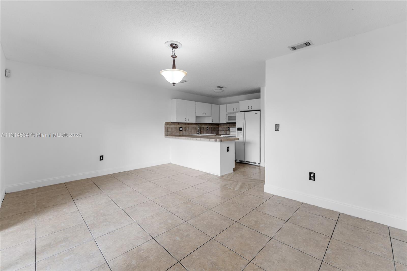 6350 Southwest 139th Avenue Miami, FL 33183 - Photo 10 of 37 a kitchen with granite countertop a stove a sink and a refrigerator