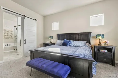 a bedroom with a bed a table and chair