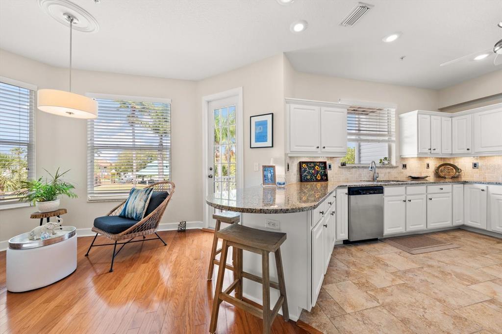 103 Shoals Circle North Redington Beach, FL 33708 - Photo 11 of 69 a kitchen with granite countertop a stove a sink a dining table and chairs