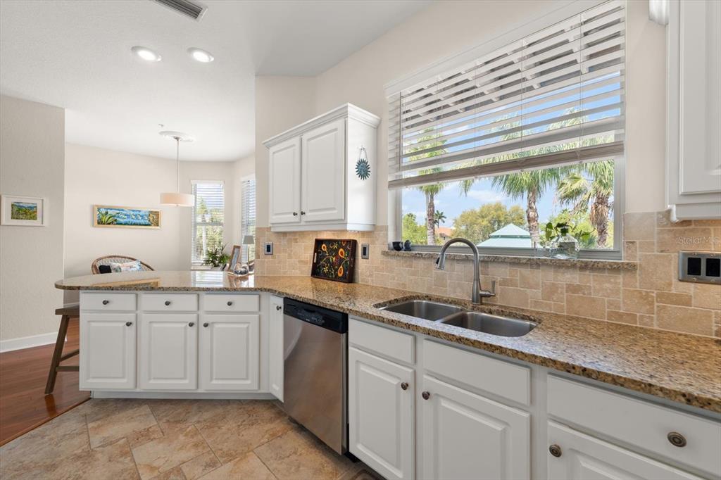 103 Shoals Circle North Redington Beach, FL 33708 - Photo 16 of 69 a kitchen with granite countertop white cabinets white appliances and a sink