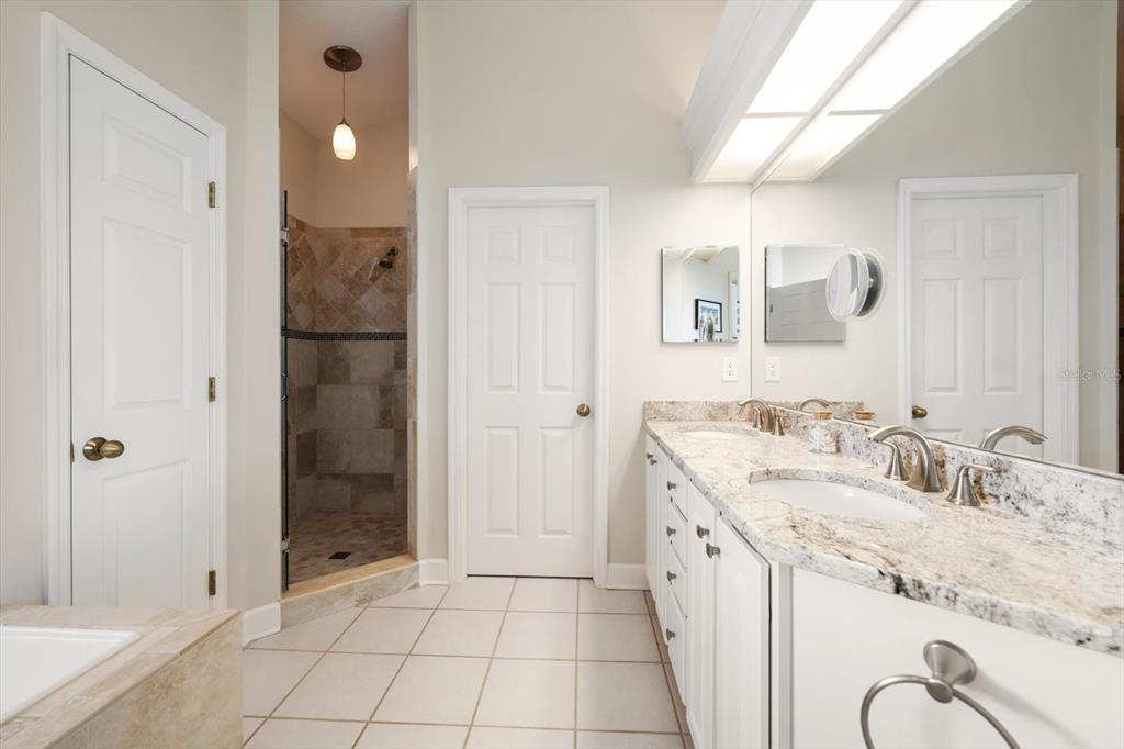 103 Shoals Circle North Redington Beach, FL 33708 - Photo 33 of 69 a spacious bathroom with a granite countertop sink a mirror and shower