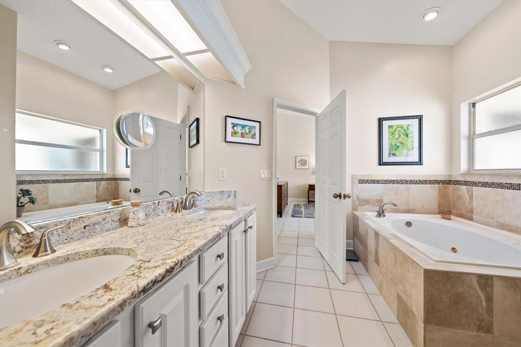 103 Shoals Circle North Redington Beach, FL 33708 - Photo 34 of 69 a spacious bathroom with a granite countertop tub sink and mirror