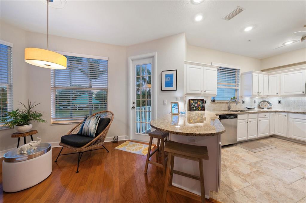 103 Shoals Circle North Redington Beach, FL 33708 - Photo 47 of 69 a kitchen with stainless steel appliances kitchen island granite countertop a sink dishwasher a stove a refrigerator a dining table and chairs with wooden floor