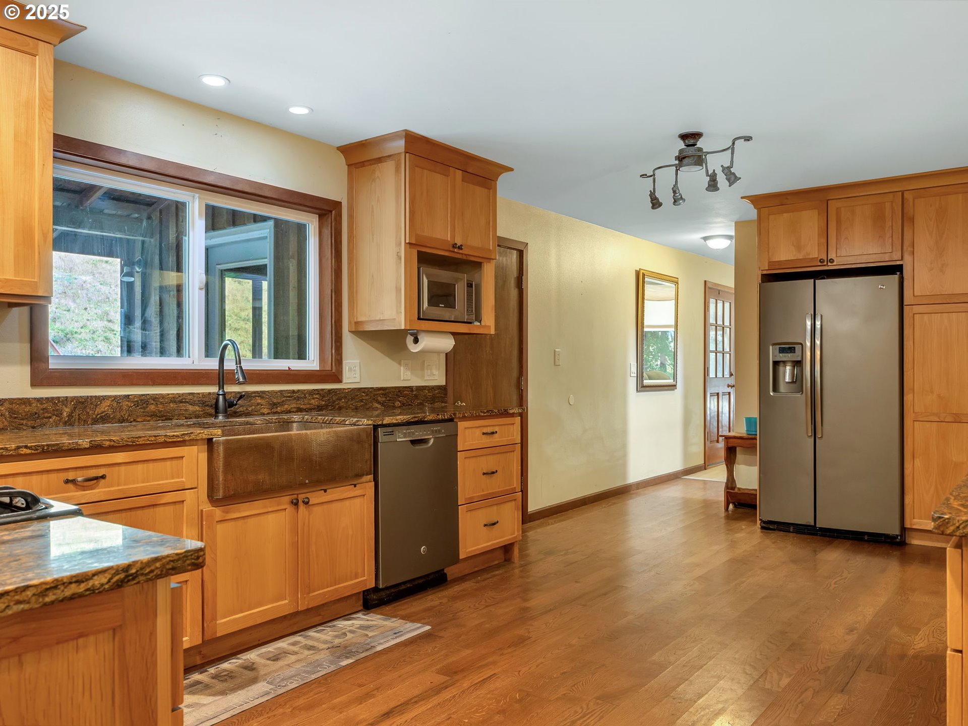 42274 Ziak-Gnat Creek Road Astoria, OR 97103 - Photo 14 of 48 a kitchen with stainless steel appliances granite countertop a refrigerator a sink dishwasher a stove and a dining table with wooden floor