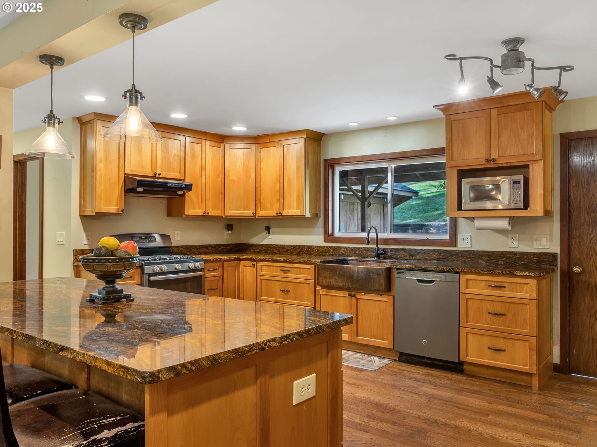 42274 Ziak-Gnat Creek Road Astoria, OR 97103 - Photo 17 of 48 a kitchen with a stove a sink a center island and wooden floor