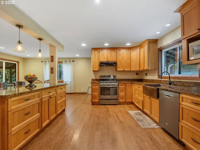 a large kitchen with stainless steel appliances granite countertop a stove and a sink