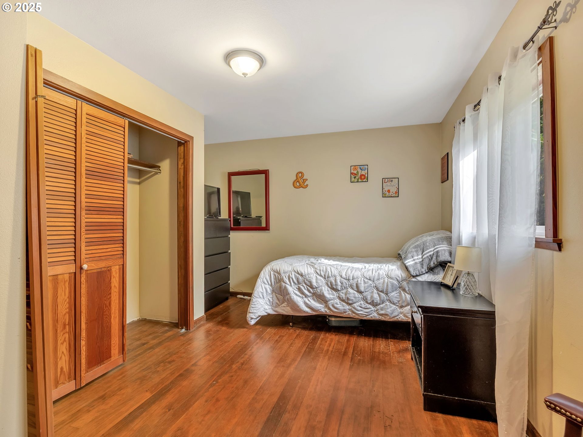 42274 Ziak-Gnat Creek Road Astoria, OR 97103 - Photo 24 of 48 a bedroom with a bed and wooden floor