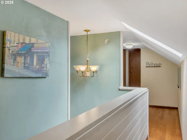 a view of a hallway with wooden floor and closet