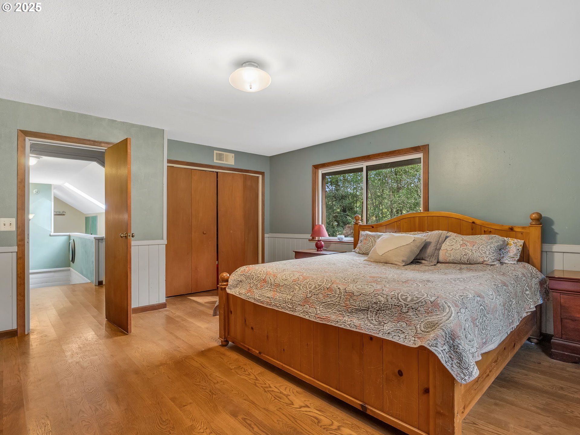 42274 Ziak-Gnat Creek Road Astoria, OR 97103 - Photo 29 of 48 a bedroom with a large bed and a chandelier