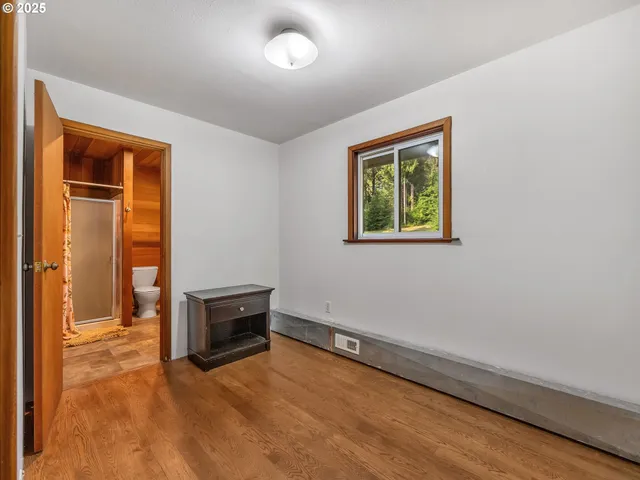 a view of a hallway with wooden floor windows and a livingroom