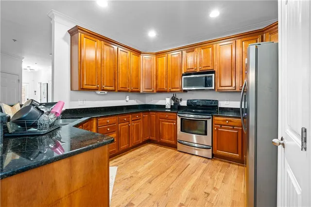 a kitchen with stainless steel appliances granite countertop a stove a sink and a microwave
