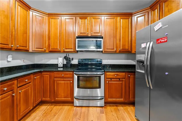 a kitchen with stainless steel appliances granite countertop a stove a sink and a refrigerator