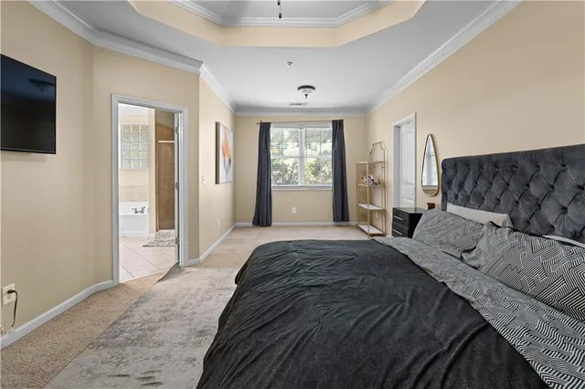 a spacious bedroom with a bed and a flat screen tv