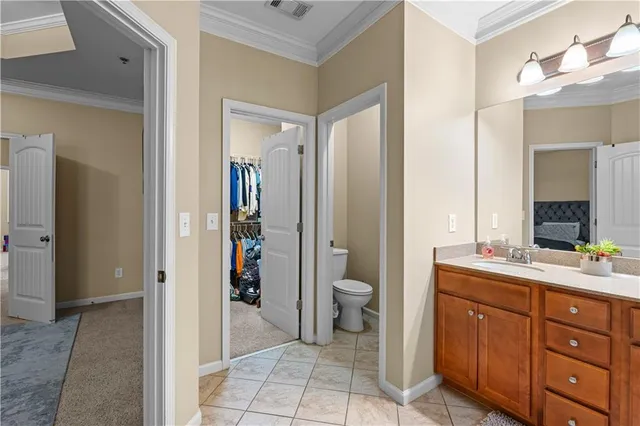 a spacious bathroom with a granite countertop sink toilet and mirror