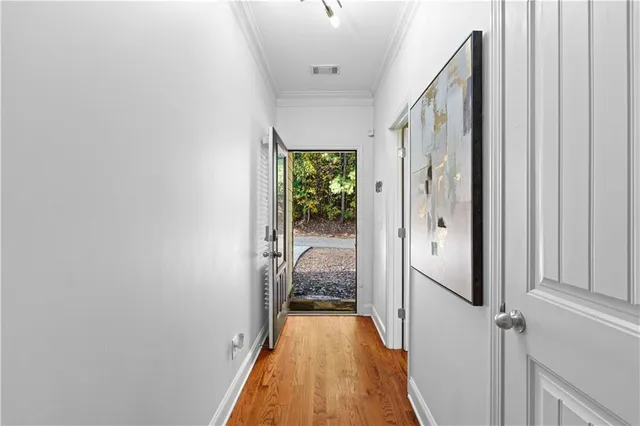 a view of a hallway with wooden floor and staircase
