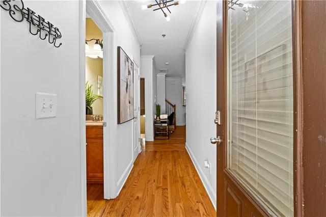 a view of a hallway with wooden floor and a bathroom