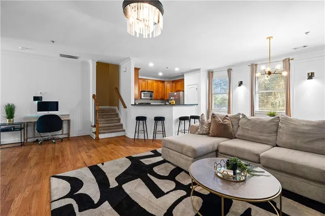 a living room with furniture a fireplace and a chandelier