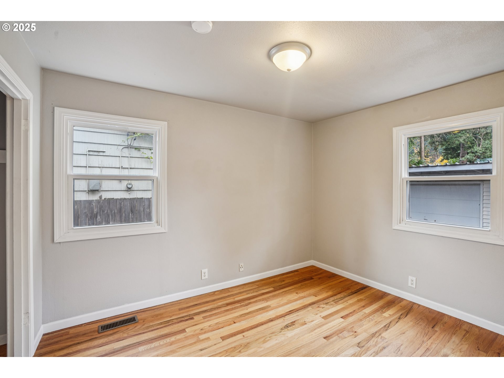 14806 Southeast Bush Street Portland, OR 97236 - Photo 14 of 33 a view of an empty room with window and wooden floor