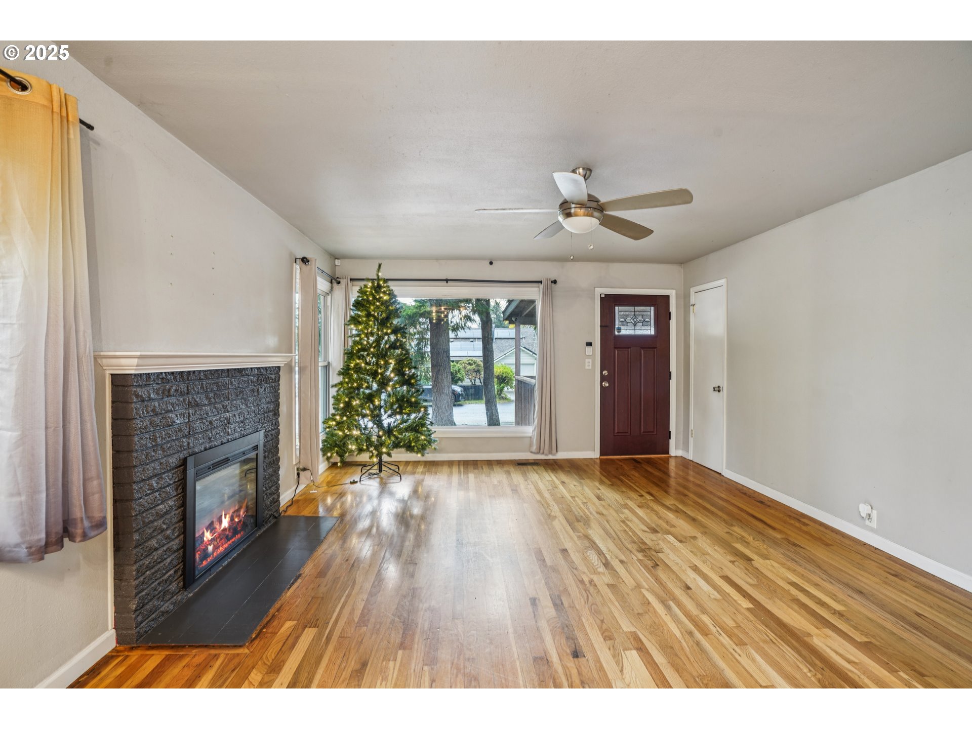 14806 Southeast Bush Street Portland, OR 97236 - Photo 6 of 33 a view of an empty room with wooden floor fireplace and a window